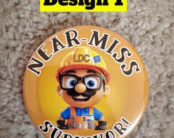 Puede incluir: Un botón amarillo con el texto "Near-Miss Survivor!" en letras negras. Un personaje de dibujos animados con un casco amarillo, una camisa azul y un chaleco naranja está en el centro del botón.
