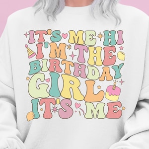 Puede incluir: Sudadera blanca con un gráfico colorido que dice "It's Me Hi I'm The Birthday Girl It's Me" con un pastel de cumpleaños y estrellas.