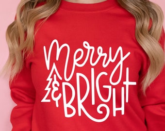 Może przedstawiać: Czerwona bluza z białym napisem "Merry & Bright".