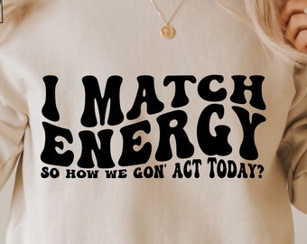 May include: A white sweatshirt with black text that reads "I Match Energy So How We Gon' Act Today?"