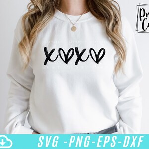 May include: White sweatshirt with a black graphic design that says "XOXO" with hearts replacing the "O"s.