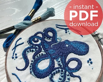 May include: Embroidered hoop art featuring an octopus with blue and light blue thread on a white fabric background. The hoop is made of wood and has a natural finish.