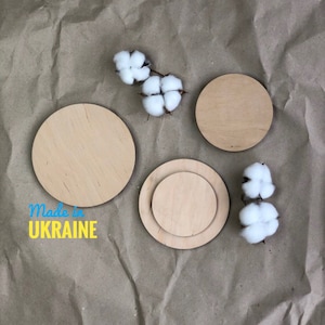 Puede incluir: Tres círculos de madera de diferentes tamaños, con un acabado de madera natural, sobre un fondo de papel marrón. Los círculos están dispuestos en forma de semicírculo. El texto "Made in UKRAINE" es visible en la esquina inferior izquierda de la imagen.