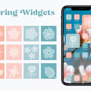 May include: A phone screen with a spring-themed design. The icons are in a grid pattern and feature flowers, leaves, and other spring-related imagery. The phone is on a background of pink and white flowers.