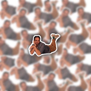 May include: A sticker featuring a man in a relaxed pose, wearing a gray shirt and brown pants. The sticker has a white border and is set against a blurred background of similar images.