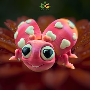 May include: A whimsical, pink ladybug figurine with heart-shaped accents. The ladybug's wings are a vibrant pink with white heart-shaped spots. The eyes are large and black with heart-shaped pupils, and it has a smiling mouth. The ladybug is set against a blurred, orange background.