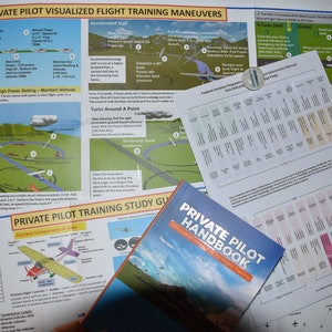 May include: A close-up of a private pilot training study guide and handbook. The guide features a colourful diagram of a plane performing a steep turn manoeuvre. The handbook is titled "Private Pilot Handbook" and is open to a page with a diagram of a plane.