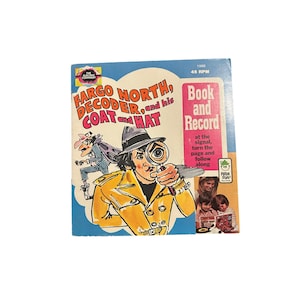 May include: A vintage children's record album titled "Fargo North, Decoder, and his Coat and Hat." The cover features a cartoon detective in a yellow coat and hat, holding a magnifying glass. The album is a "Book and Record" set.