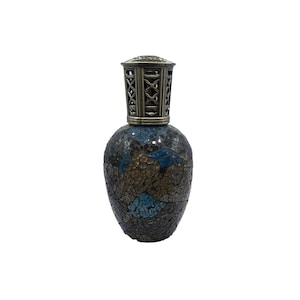 Puede incluir: Lámpara de aceite decorativa con cuerpo de mosaico de vidrio en tonos azules, marrones y dorados. La lámpara tiene una parte superior de metal con un intrincado diseño de celosía. La lámpara está diseñada para contener aceite y es un adorno decorativo para el hogar.