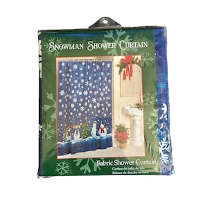 May include: A packaged fabric shower curtain featuring a dark blue background with white snowflakes and a row of snowmen at the bottom. The packaging displays the text Snowman Shower Curtain and Fabric Shower Curtain with a product photo.