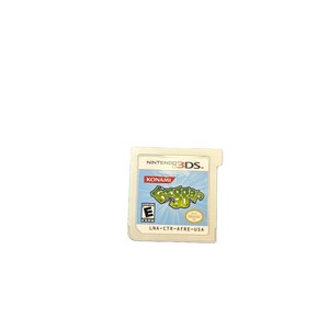 Puede incluir: Un cartucho de juego de Nintendo 3DS para Frogger 3D. El cartucho es blanco con una etiqueta azul y verde con el logotipo del juego y el logotipo de Konami. La clasificación ESRB es visible.