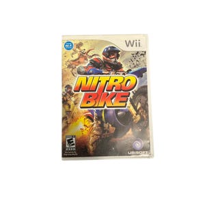 May include: A Wii game case for "Nitro Bike" featuring a motocross racer in a helmet and gear. The game title is in large yellow and orange letters. The case has a white background with the Wii logo.