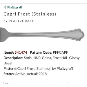 May include: A stainless steel fork from the Capri Frost collection by Pfaltzgraff. The fork has a glossy finish and a decorative handle. The item number is 541474.