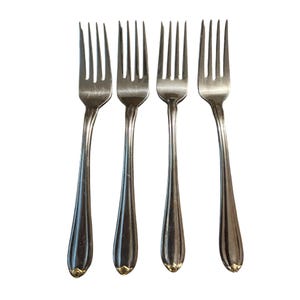 May include: Four silver forks with a classic design. Each fork has a long, slender handle with a decorative gold-colored accent at the base. The tines are evenly spaced and slightly curved.