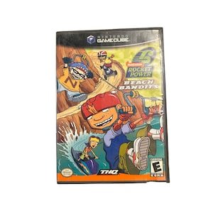 May include: A Nintendo GameCube video game case for "Rocket Power: Beach Bandits." The cover art features cartoon characters surfing and riding a rope swing. The game is rated "E" for Everyone.