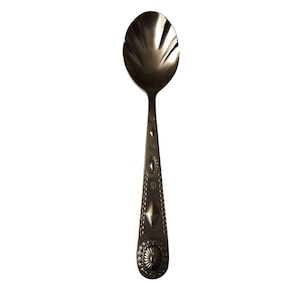May include: A silver-colored spoon with an oval bowl and a decorative handle. The handle features a series of embossed designs, including a diamond shape and a floral pattern at the base. The spoon is designed for serving.
