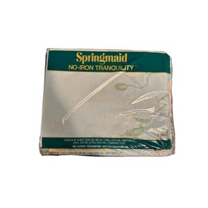 Puede incluir: Una sábana plana Springmaid king size empaquetada para un colchón de 198 x 203 cm. El paquete está sellado en plástico transparente y presenta el texto "Springmaid NO-IRON TRANQUILITY". La sábana mide 274 x 259 cm.