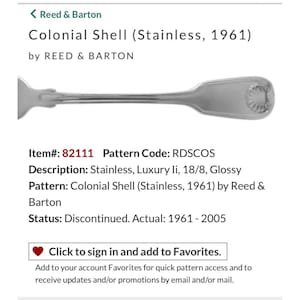Peut inclure: Une cuillère en acier inoxydable du modèle Colonial Shell de Reed & Barton. La cuillère a une finition brillante et un motif de coquillage sur le manche. Le texte "Colonial Shell (Stainless, 1961)" est visible.