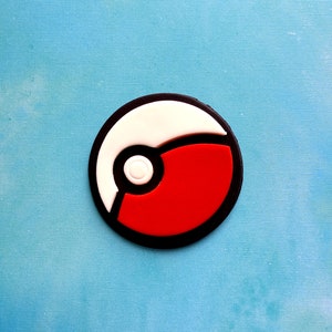 Op de afbeelding: Een zwart-witte Pok&eacute;bal met een rood midden. De Pok&eacute;bal is een populair symbool uit de Pok&eacute;mon-franchise.