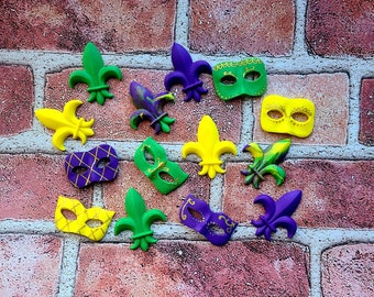 May include: A collection of Mardi Gras themed decorations, including purple, green, and gold masks and fleur-de-lis.