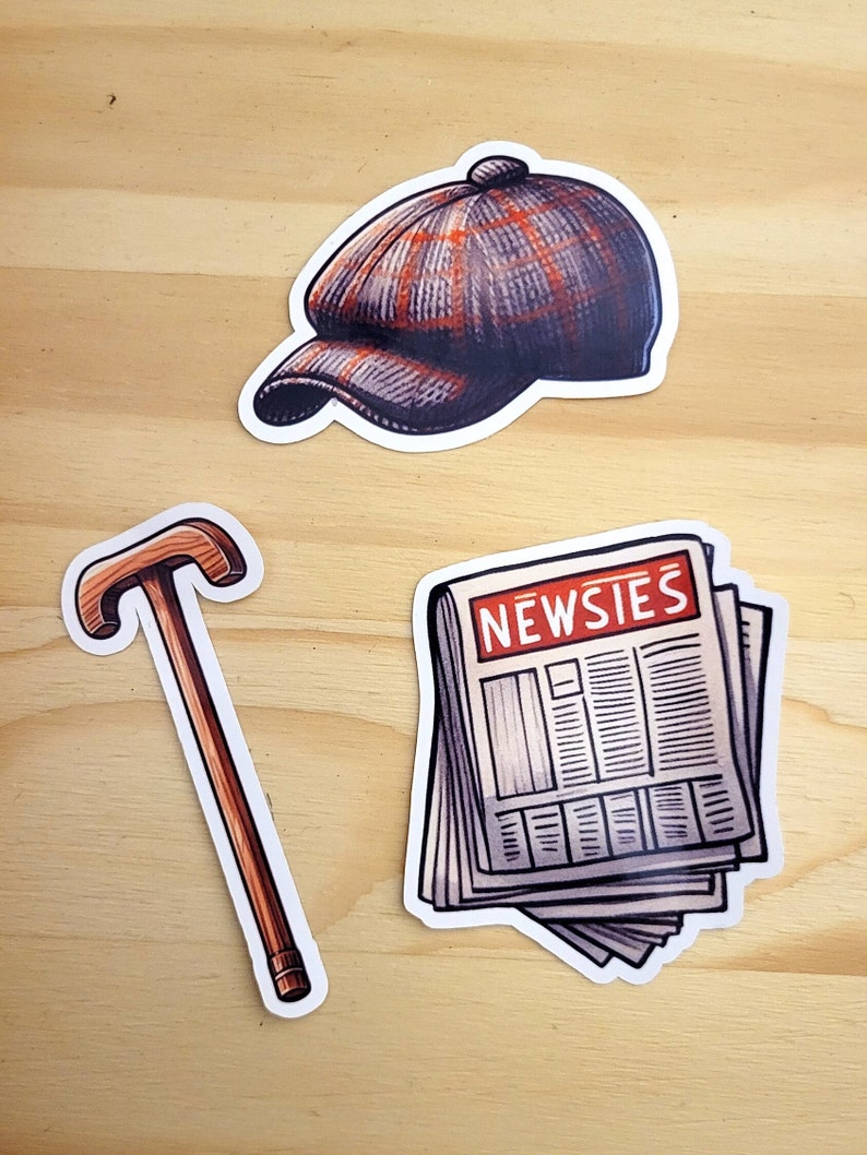 K&ouml;nnte beinhalten: Drei Aufkleber im Vintage-Stil: eine braune und graue Newsboy-M&uuml;tze, ein brauner Gehstock und ein Stapel Zeitungen mit dem in Rot gedruckten Wort "NEWSIES".