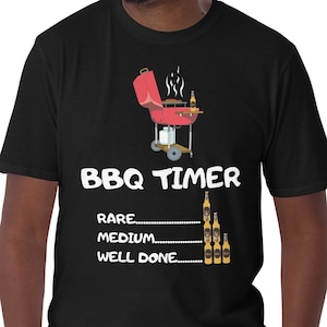 May include: Black t-shirt with a white graphic of a red grill and the text "BBQ TIMER" with a list of "RARE", "MEDIUM", and "WELL DONE" with beer bottles representing the time.