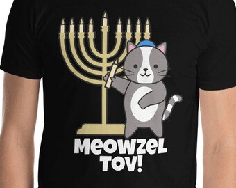 May include: A black t-shirt with a gray cat wearing a blue yarmulke holding a menorah with the text "Meowzel Tov!"