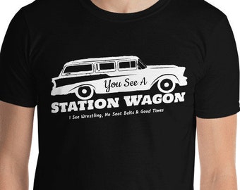 Puede incluir: Camiseta negra con un gráfico blanco de un coche familiar vintage y el texto "You See A STATION WAGON". Debajo, el texto dice "I See Wrestling, No Seat Belts & Good Times".