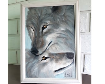 May include: An oil painting in a white frame depicting two wolves with grey and white fur and amber eyes, positioned one above the other. The artwork features visible brushstrokes and a signature in the bottom right corner, accompanied by two paintbrushes.