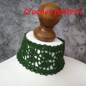 May include: A green crocheted choker necklace on a white mannequin. The choker is made with a delicate, lacy pattern.