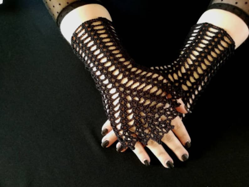 May include: A pair of black crocheted fingerless gloves with a delicate openwork pattern.