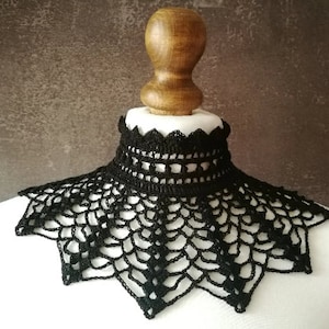 May include: A black crocheted lace collar with a scalloped edge.