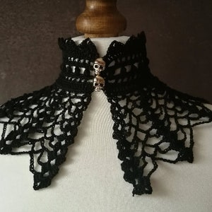 May include: Black crocheted lace collar with two silver skull embellishments.