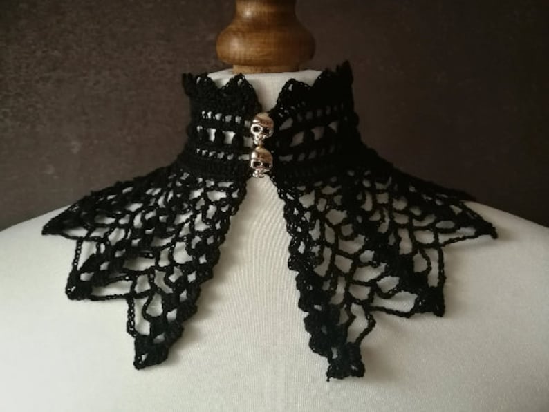 May include: Black crocheted lace collar with two silver skull embellishments.