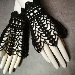 May include: A pair of black crocheted fingerless gloves with a lacy design.