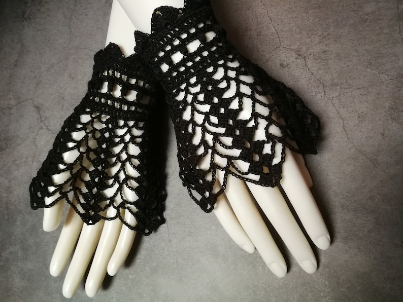 May include: A pair of black crocheted fingerless gloves with a lacy design.