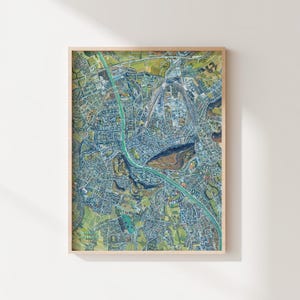 May include: A detailed aerial map of a city with a river running through it. The map is printed in shades of blue, green, and brown, and shows the layout of the city's streets, buildings, and parks.