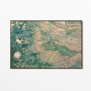 May include: A framed painting of an aerial view, showing a landscape with mountains, rivers, and valleys. The artwork uses shades of green, tan, and blue, with a dark brown frame. The painting is a detailed representation of a natural environment.