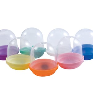 Puede incluir: Ocho cápsulas de plástico transparente con tapas de colores. Las tapas son moradas, verdes, amarillas, naranjas, rosas y azules.