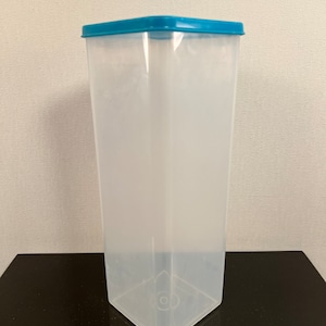 May include: A clear plastic container with a blue lid. The container is rectangular and has a square base.