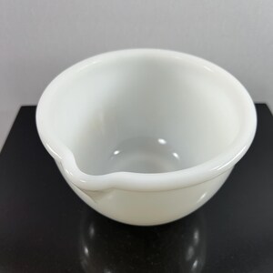May include: A white ceramic mixing bowl with a slightly uneven rim.