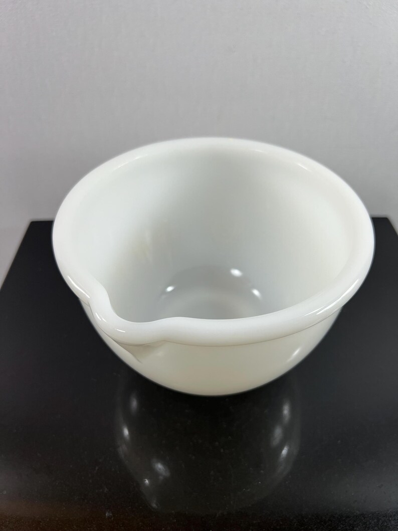 May include: A white ceramic mixing bowl with a slightly uneven rim.