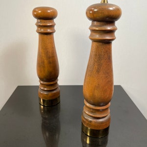 Peut inclure: Un ensemble de deux sali&egrave;res et poivri&egrave;res en bois avec des dessus en laiton. Les sali&egrave;res sont brunes et ont une finition lisse et polie.