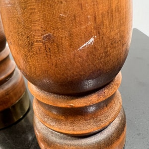 Peut inclure: Deux sali&egrave;res et poivri&egrave;res en bois avec des bases en laiton. Les sali&egrave;res sont brunes et ont une forme ronde et lisse.
