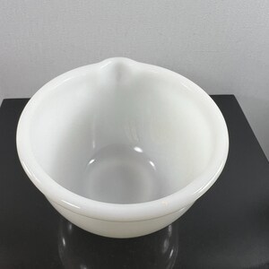 May include: A white ceramic mixing bowl with a pouring spout. The bowl is round and has a smooth, glossy finish.