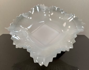 May include: A white glass bowl with a scalloped edge. The bowl is made of clear glass and has a frosted finish.