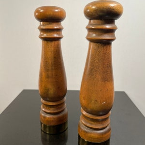 Peut inclure: Un ensemble de deux sali&egrave;res et poivri&egrave;res en bois avec des dessus en laiton. Les sali&egrave;res sont brunes et ont une finition textur&eacute;e.