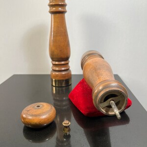 Peut inclure: Un ensemble de trois moulins &agrave; poivre et &agrave; sel en bois avec une base en velours rouge. Les moulins ont un design classique avec un sommet rond et un corps cylindrique. La base est un petit carr&eacute; avec un dessus en velours rouge.