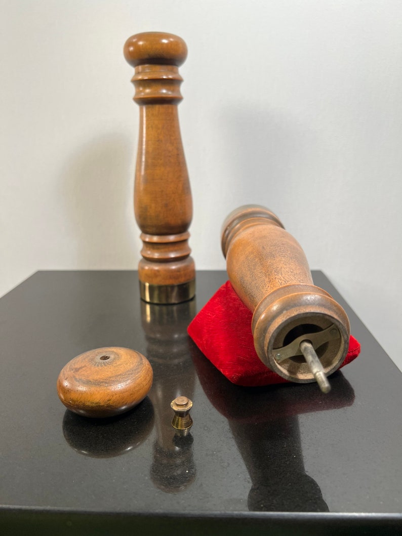 Peut inclure: Un ensemble de trois moulins &agrave; poivre et &agrave; sel en bois avec une base en velours rouge. Les moulins ont un design classique avec un sommet rond et un corps cylindrique. La base est un petit carr&eacute; avec un dessus en velours rouge.