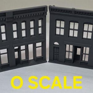 May include: Two gray, plastic, O scale model building facades with windows and doors. The facades are designed to be used in model railroading.